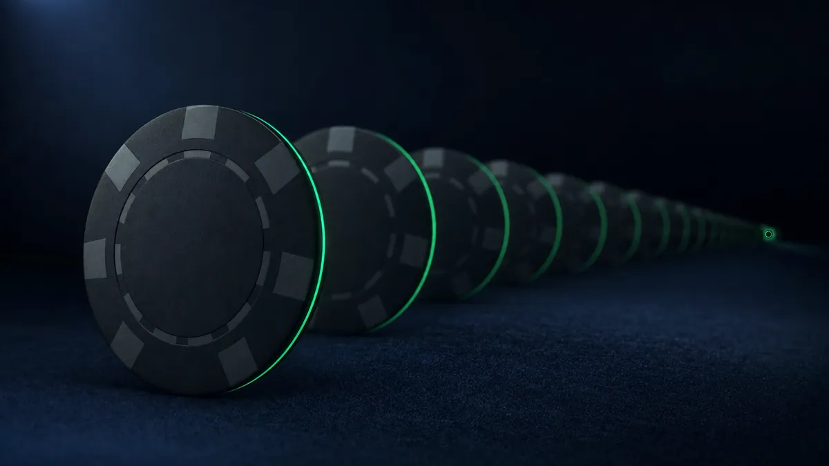 A long row of black casino chips receding into darkness