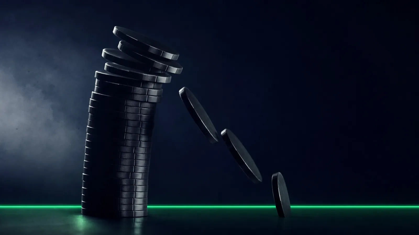 A tall stack of casino chips caught at the moment it topples